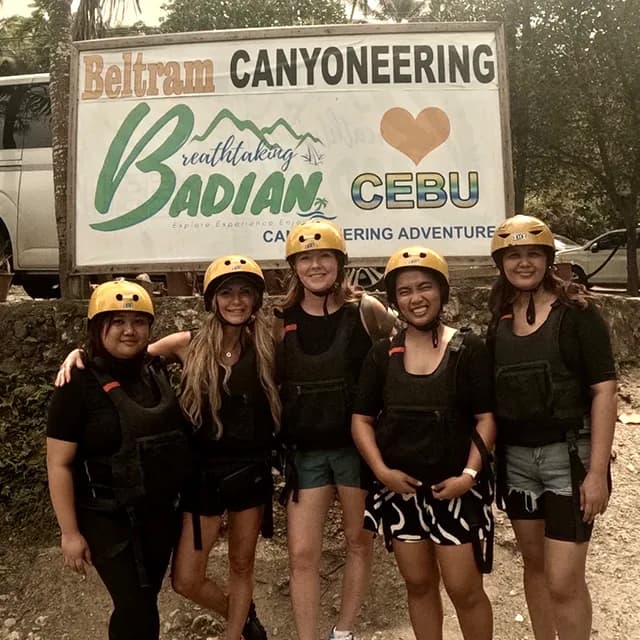 Danielle Keasling and friends in helmets at the Badian canyoneering sign in Cebu